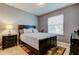 Cozy bedroom with a black bed frame, side table, and bright window at 13217 Canopy Creek Dr, Tampa, FL 33625