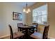 Bright dining area features a round wood table with seating for four under a decorative chandelier at 13217 Canopy Creek Dr, Tampa, FL 33625
