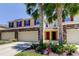 Charming townhome with a stone facade, red shutters, lush landscaping, and an inviting front entrance at 13217 Canopy Creek Dr, Tampa, FL 33625