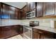 Modern kitchen with stainless steel appliances, granite counters, and sleek dark wood cabinets at 13217 Canopy Creek Dr, Tampa, FL 33625