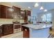 Modern kitchen with dark wood cabinets, stainless steel appliances, granite countertops, and island seating at 13217 Canopy Creek Dr, Tampa, FL 33625