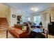 Open-concept living room showcasing hardwood floors, comfortable seating, and access to the staircase and kitchen at 13217 Canopy Creek Dr, Tampa, FL 33625