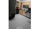 A modern kitchen featuring a black and white tile floor, light wood cabinets, and stainless steel appliances at 1329 Tuscola St, Clearwater, FL 33756