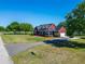 An aerial view of a red house with a long driveway and plenty of yard space with mature trees at 14807 Capps Estates Ln, Wimauma, FL 33598