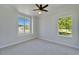 Comfortable bedroom with neutral carpet, crown molding, and natural light from two windows at 14807 Capps Estates Ln, Wimauma, FL 33598