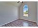 Bright bedroom featuring a vaulted ceiling, wood-look floors, and large window with a view at 14807 Capps Estates Ln, Wimauma, FL 33598