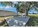 Rustic wooden gazebo on a concrete foundation, set in a well-maintained yard with a white fence at 14807 Capps Estates Ln, Wimauma, FL 33598