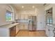 Kitchen showcasing stainless steel refrigerator and dishwasher, with white cabinets and light countertops at 14807 Capps Estates Ln, Wimauma, FL 33598