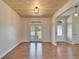 Spacious living room with wood floors, wooden ceiling and natural light from large windows at 14807 Capps Estates Ln, Wimauma, FL 33598