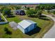 View of a steel outbuilding with a large door, nestled on a green lawn next to a charming home at 14807 Capps Estates Ln, Wimauma, FL 33598