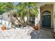 Cozy front porch featuring mature palm trees, paver patio and a bright teal front door at 15018 Greeley Dr, Tampa, FL 33625