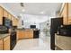 Open concept kitchen with breakfast bar, sink, and view to the living and dining areas at 15018 Greeley Dr, Tampa, FL 33625