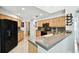 Bright kitchen with black appliances, wooden cabinets, and tile countertops at 15018 Greeley Dr, Tampa, FL 33625