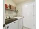 Functional laundry room with washer, dryer, shelving, and storage space at 15018 Greeley Dr, Tampa, FL 33625