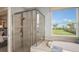 Luxurious bathroom featuring a soaking tub, separate shower, and serene outdoor views at 1702 Trailhead Ln, Zephyrhills, FL 33541