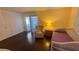 Bedroom featuring wood floors, a closet, slider to the outside and a comfortable chair at 1801 Bedford Ln # 46, Sun City Center, FL 33573