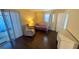 Bedroom featuring wood floors, a closet, slider to the outside and a comfortable chair at 1801 Bedford Ln # 46, Sun City Center, FL 33573