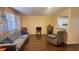 Cozy living room featuring hardwood floors, comfortable gray couch, and open view to the kitchen at 1801 Bedford Ln # 46, Sun City Center, FL 33573