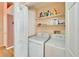 Functional laundry room with side by side washer and dryer and overhead storage shelves at 2033 Shadow Pine Dr, Brandon, FL 33511