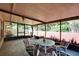 Enclosed patio with comfortable seating, tile floor, and views of the landscaped backyard at 2033 Shadow Pine Dr, Brandon, FL 33511