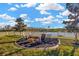 Beautiful backyard with a waterfront view, a fire pit, rocking chairs, and a white fence at 21832 Crest Meadow Dr, Land O Lakes, FL 34637