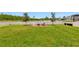 Lush backyard featuring a waterfront view, a fire pit, seating, and a white fence at 21832 Crest Meadow Dr, Land O Lakes, FL 34637