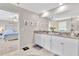 Bathroom with double vanity, granite countertop and view into bedroom at 21832 Crest Meadow Dr, Land O Lakes, FL 34637