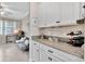 Butler pantry between kitchen and office with granite countertops and wine storage at 21832 Crest Meadow Dr, Land O Lakes, FL 34637