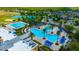 Aerial view of a resort-style community pool area with palm trees, lounge chairs, and a splash pad at 21832 Crest Meadow Dr, Land O Lakes, FL 34637