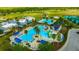 Aerial view of a community pool area with palm trees, lounge chairs, pool, and a splash pad at 21832 Crest Meadow Dr, Land O Lakes, FL 34637