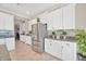 Kitchen features stainless steel refrigerator with white cabinets and tile floor at 21832 Crest Meadow Dr, Land O Lakes, FL 34637