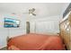 Spacious bedroom with an ornate bed frame, ceiling fan and a mounted TV screen at 2362 Mary Ln, Clearwater, FL 33763