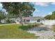 Inviting single-story home with mature trees, well-kept lawn, and a quaint gravel driveway at 2362 Mary Ln, Clearwater, FL 33763