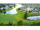 Expansive aerial view of golf course community, showcasing homes around a lake at 2401 Richmond Greens Ct, Sun City Center, FL 33573
