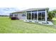 Wide shot of backyard featuring sun room with decorative rocks and planters at 2401 Richmond Greens Ct, Sun City Center, FL 33573