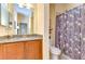 Bathroom featuring wood vanity, granite countertop, and shower with decorative curtain at 2401 Richmond Greens Ct, Sun City Center, FL 33573