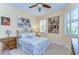 Bedroom with large bed, tile floor, decorations, and large window with plantation shutters at 2401 Richmond Greens Ct, Sun City Center, FL 33573