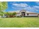 A lovely single story home with well manicured yard, tropical landscaping, and paver walkway at 2401 Richmond Greens Ct, Sun City Center, FL 33573