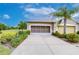 Exterior shot of a two car garage with a paved driveaway and manicured landscaping at 2401 Richmond Greens Ct, Sun City Center, FL 33573