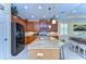 Spacious kitchen with a center island, granite countertops, wooden cabinets, and black appliances at 2401 Richmond Greens Ct, Sun City Center, FL 33573