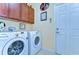 Well-equipped laundry room features a washer, dryer, and storage cabinets at 2401 Richmond Greens Ct, Sun City Center, FL 33573