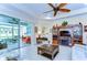 Inviting living room featuring a ceiling fan, TV, and sliders to the sun room at 2401 Richmond Greens Ct, Sun City Center, FL 33573