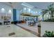Spacious lobby area featuring a bar, tables, tile flooring, and elegant decor with lush plants and artwork at 2401 Richmond Greens Ct, Sun City Center, FL 33573