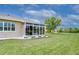 Back of house featuring a sun room with exterior view of the landscaped lawn at 2401 Richmond Greens Ct, Sun City Center, FL 33573