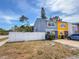 Two-story townhome featuring a white fence, tidy landscaping, and a convenient driveway at 2930 S Pines Dr # 109, Largo, FL 33771