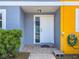 Inviting front entryway with a white door, stone landing, and vibrant blue and yellow exterior at 2930 S Pines Dr # 109, Largo, FL 33771