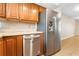 Kitchen area features stainless steel dishwasher and refrigerator, and wooden cabinets at 2930 S Pines Dr # 109, Largo, FL 33771