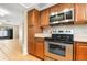 Kitchen featuring stainless steel appliances, wood cabinets, and a view of the living room at 2930 S Pines Dr # 109, Largo, FL 33771