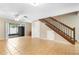 Bright living room with tile flooring, ceiling fan, and wooden staircase leading to the second floor at 2930 S Pines Dr # 109, Largo, FL 33771