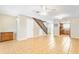 Open-concept living room with tile floors, a wooden staircase, and a view into the adjacent kitchen at 2930 S Pines Dr # 109, Largo, FL 33771